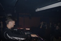 a man is playing a dj in a dark room